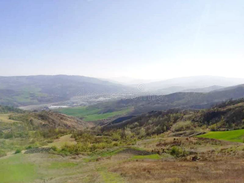 Het bergpanorama in het vroege voorjaar, wanneer de natuur wakker wordt en het groene weiland en bomen ziet, en in de afstand in royalty-vrije stock foto Het bergpanorama in het vroege voorjaar, wanneer de natuur wakker wordt en het groene weiland en bomen ziet, en in de afstand in royalty-vrije stock foto
