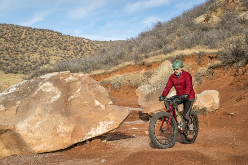 Het berijden van een vette fiets op de sleep van de bergwoestijn stock fotografie