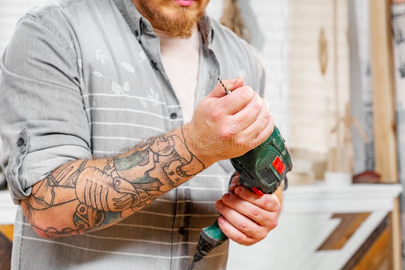 Het beroep, het timmerwerk, de houtbewerking en het mensenconcept, timmerman bereiden de boor voor het werk voor stock afbeelding Het beroep, het timmerwerk, de houtbewerking en het mensenconcept, timmerman bereiden de boor voor het werk voor stock afbeelding