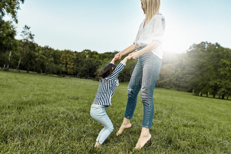 Het blije meisje spelen met haar moeder op groen gras Houdende van mooie vrouw en haar dochter het besteden tijd samen en stock foto Het blije meisje spelen met haar moeder op groen gras Houdende van mooie vrouw en haar dochter het besteden tijd samen en stock foto