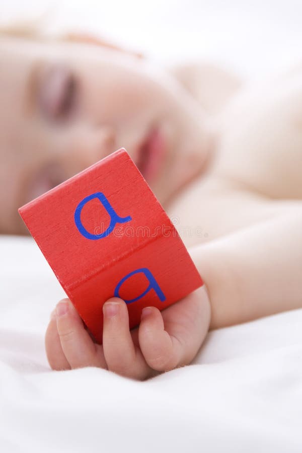 Slaapend babytje dat een ABC-blok vasthoudt royalty-vrije stock afbeelding