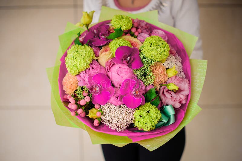 Het boeket van de meisjesholding van roze en groene bloemen royalty-vrije stock afbeelding Het boeket van de meisjesholding van roze en groene bloemen royalty-vrije stock afbeelding