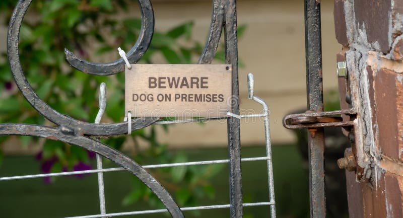 Het bronsteken VOORZICHTIG ZIJN HOND OP GEBOUW op oude poort royalty-vrije stock afbeeldingen Het bronsteken VOORZICHTIG ZIJN HOND OP GEBOUW op oude poort royalty-vrije stock afbeeldingen