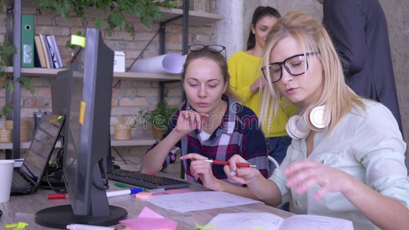 Het bureauwerk, jonge creatieve vrouwelijke collega's die bedrijfsideeën bespreken