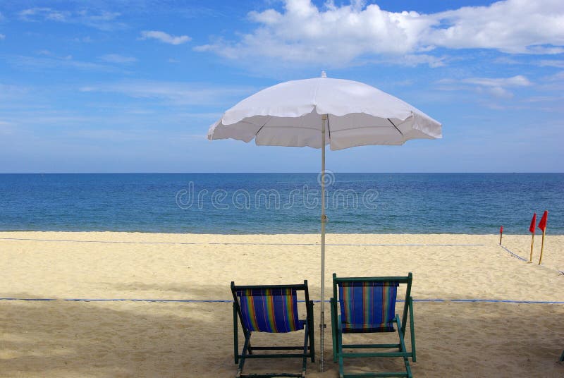 Het canvas van het bed met heldere paraplu's op het strand