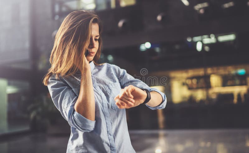 Het charmante jonge bedrijfsvrouw spreken met partner via mobiele telefoon terwijl status op modern commercieel centrum stock afbeelding Het charmante jonge bedrijfsvrouw spreken met partner via mobiele telefoon terwijl status op modern commercieel centrum stock afbeelding