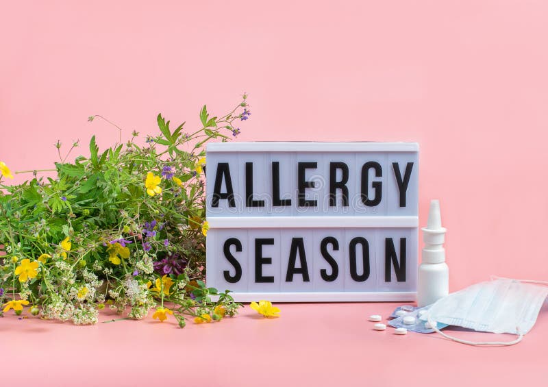 Het concept preventie van seizoensallergieën. verse bloemen medische maskers pillen druppelen geneesmiddel roze achtergrond.