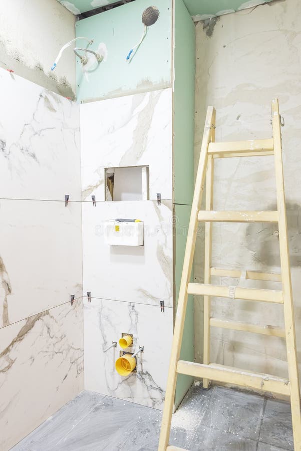 Het concept van de badkamersvernieuwing Marmeren keramische tegels met verbindingsstukken en grijze cementmuren in badkamers die, royalty-vrije stock afbeelding Het concept van de badkamersvernieuwing Marmeren keramische tegels met verbindingsstukken en grijze cementmuren in badkamers die, royalty-vrije stock afbeelding