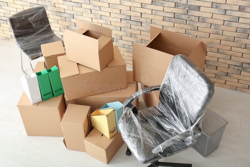 Het concept van de bureaubeweging Kartondozen en stoelen op vloer royalty-vrije stock foto Het concept van de bureaubeweging Kartondozen en stoelen op vloer royalty-vrije stock foto
