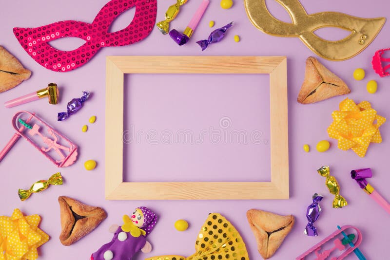 Het concept van de Purimvakantie met houten kader, Carnaval-masker en hamans orenkoekjes op purpere achtergrond Hoogste mening va stock afbeeldingen Het concept van de Purimvakantie met houten kader, Carnaval-masker en hamans orenkoekjes op purpere achtergrond Hoogste mening va stock afbeeldingen