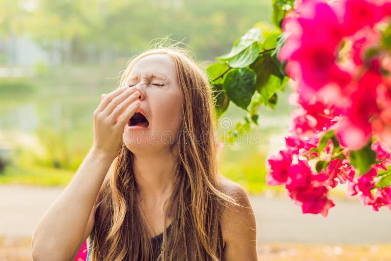 Het concept van de stuifmeelallergie De jonge vrouw gaat niezen Bloeiende bomen op achtergrond stock foto's Het concept van de stuifmeelallergie De jonge vrouw gaat niezen Bloeiende bomen op achtergrond stock foto's