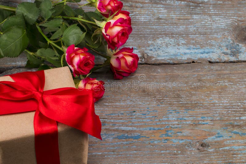 Het concept van de valentijnskaartendag met rode roze bloemen en giftdoos streeft na stock afbeelding Het concept van de valentijnskaartendag met rode roze bloemen en giftdoos streeft na stock afbeelding