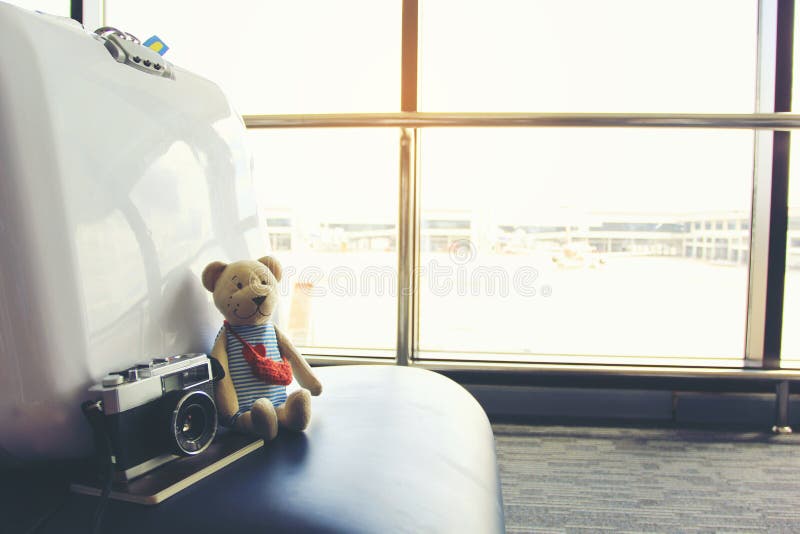 Het concept van de de zomervakantie, Teddybeer met paspoort en lege stoelen en passagier in de luchthaventerminal stock afbeeldingen Het concept van de de zomervakantie, Teddybeer met paspoort en lege stoelen en passagier in de luchthaventerminal stock afbeeldingen