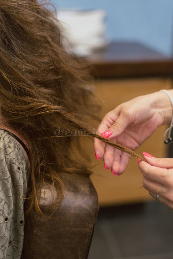 het creëren van kapsels op bruin bruin haar in de salon Het creëren van krullen bij de kapper royalty-vrije stock afbeelding het creëren van kapsels op bruin bruin haar in de salon Het creëren van krullen bij de kapper royalty-vrije stock afbeelding