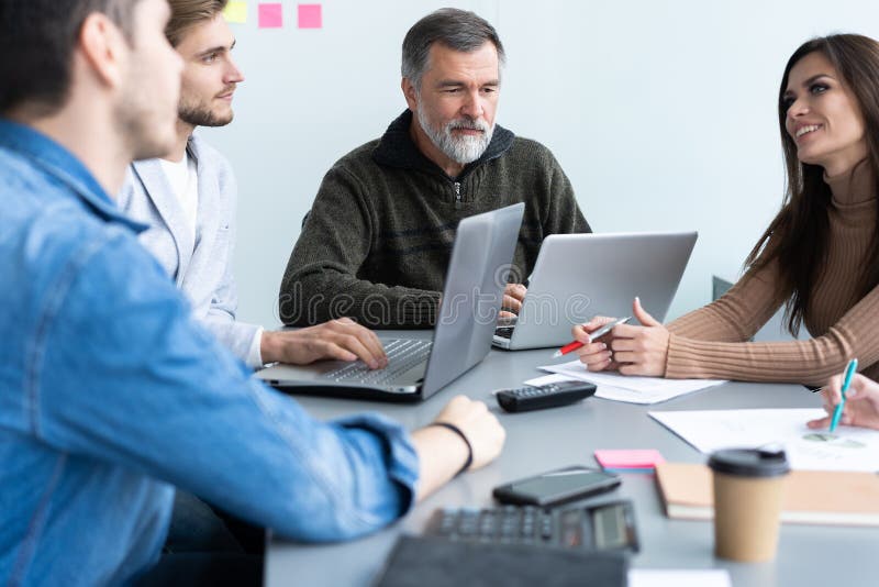 Het delen van adviezen Groep jonge moderne mensen die in slimme vrijetijdskleding zaken bespreken terwijl het werken in creatief royalty-vrije stock afbeeldingen Het delen van adviezen Groep jonge moderne mensen die in slimme vrijetijdskleding zaken bespreken terwijl het werken in creatief royalty-vrije stock afbeeldingen