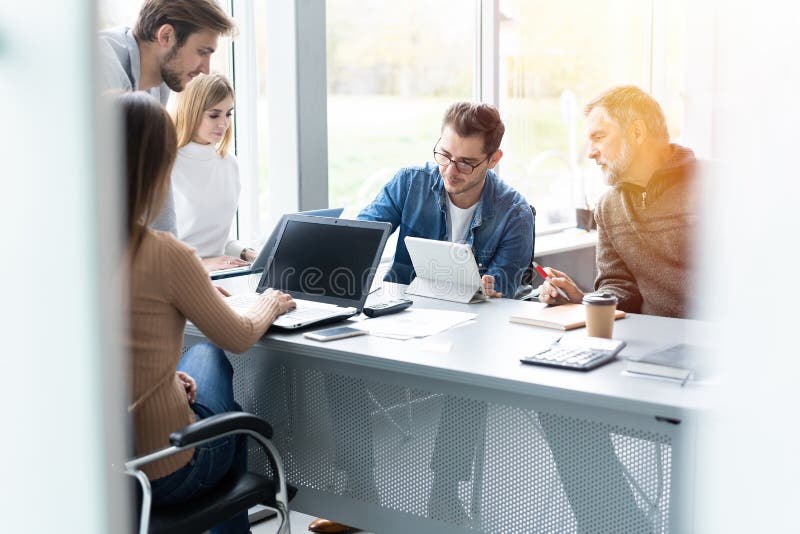 Het delen van adviezen Groep jonge moderne mensen die in slimme vrijetijdskleding zaken bespreken terwijl het werken in creatief royalty-vrije stock foto's Het delen van adviezen Groep jonge moderne mensen die in slimme vrijetijdskleding zaken bespreken terwijl het werken in creatief royalty-vrije stock foto's