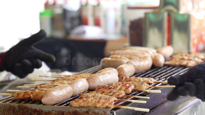 Het dichtbijzijnde beeld van de hawker die de worst bedekt en de thaise varkensslagers mo pingelen