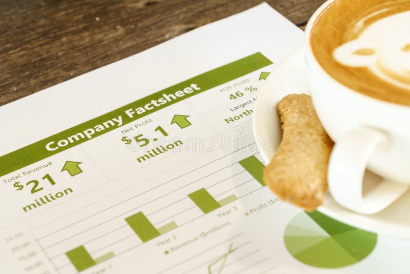 Drinking coffee while reading company financial fact sheet. Drinking coffee while reading company financial fact sheet