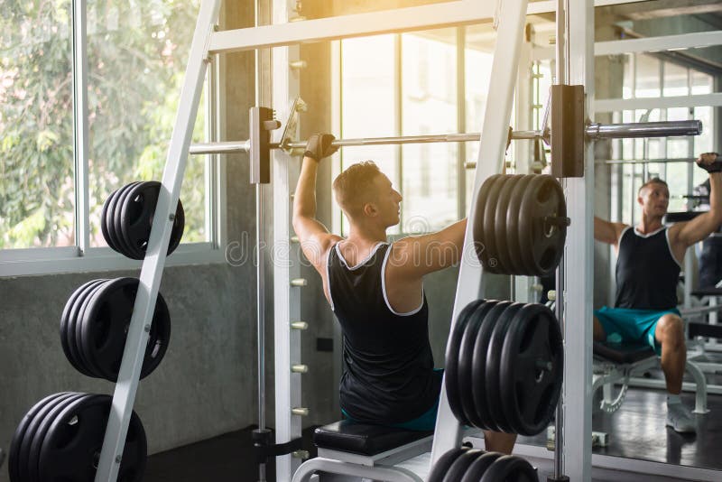 Het dwars geschikte lichaam en het spier het opheffen gewicht barbell in de gymnastiek, Sportmens het doen oefenen opleiding uit royalty-vrije stock foto's Het dwars geschikte lichaam en het spier het opheffen gewicht barbell in de gymnastiek, Sportmens het doen oefenen opleiding uit royalty-vrije stock foto's