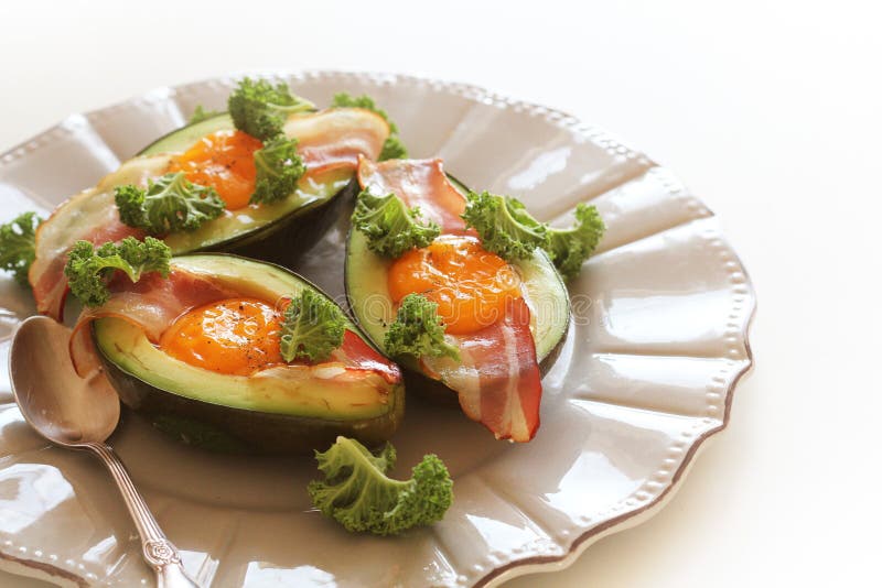 Het Eiboten van de ontbijtavocado met knapperig bacon, boerenkoolkool op witte achtergrond stock fotografie
