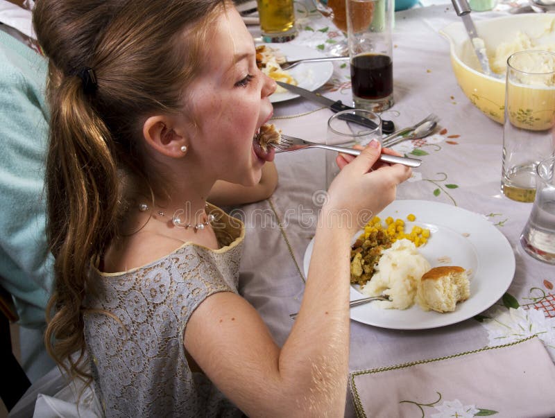 Young girl eats Thanksgiving dinner turkey. Young girl eats Thanksgiving dinner turkey