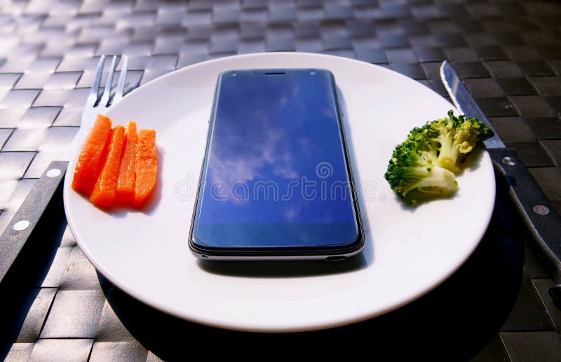 Het eten van smartphone op schotel stock afbeeldingen Het eten van smartphone op schotel stock afbeeldingen