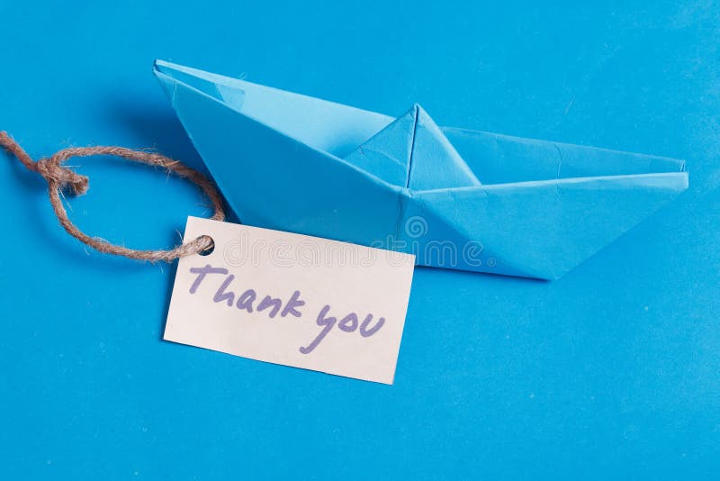 Label met de woorden 'Dank je'. Papieren bootje met een bordje royalty-vrije stock afbeelding