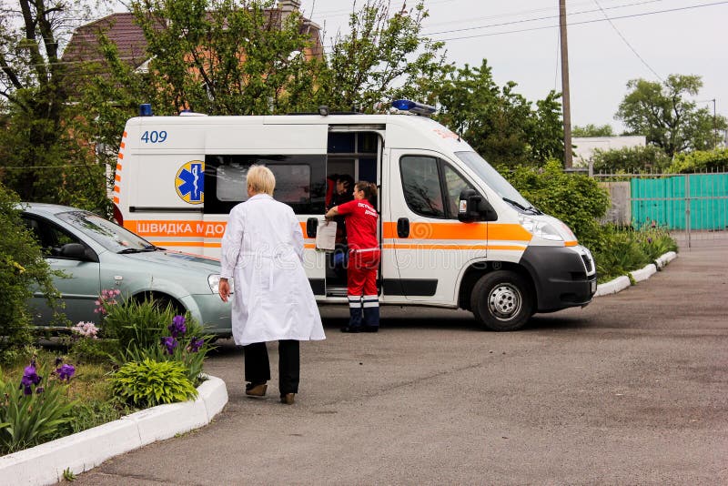 Het GEBIED van KIEV, de OEKRAÏNE - Mei 12, 2016: ziekenwagen en een verpleegster op de straat De ziekenwagen is dichtbij het ziek royalty-vrije stock fotografie Het GEBIED van KIEV, de OEKRAÏNE - Mei 12, 2016: ziekenwagen en een verpleegster op de straat De ziekenwagen is dichtbij het ziek royalty-vrije stock fotografie