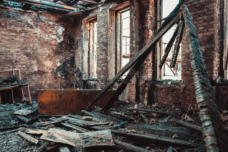 Het gebrande binnenland van het baksteenhuis met gebrand binnen meubilair, geruïneerde de bouwruimte na brand royalty-vrije stock afbeelding Het gebrande binnenland van het baksteenhuis met gebrand binnen meubilair, geruïneerde de bouwruimte na brand royalty-vrije stock afbeelding