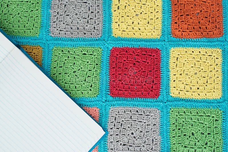 het gehaakte kanttafelkleed van multicolored vierkanten siert, blad van notitieboekje, hoogste mening, plaats voor tekst, natuurl stock afbeelding het gehaakte kanttafelkleed van multicolored vierkanten siert, blad van notitieboekje, hoogste mening, plaats voor tekst, natuurl stock afbeelding