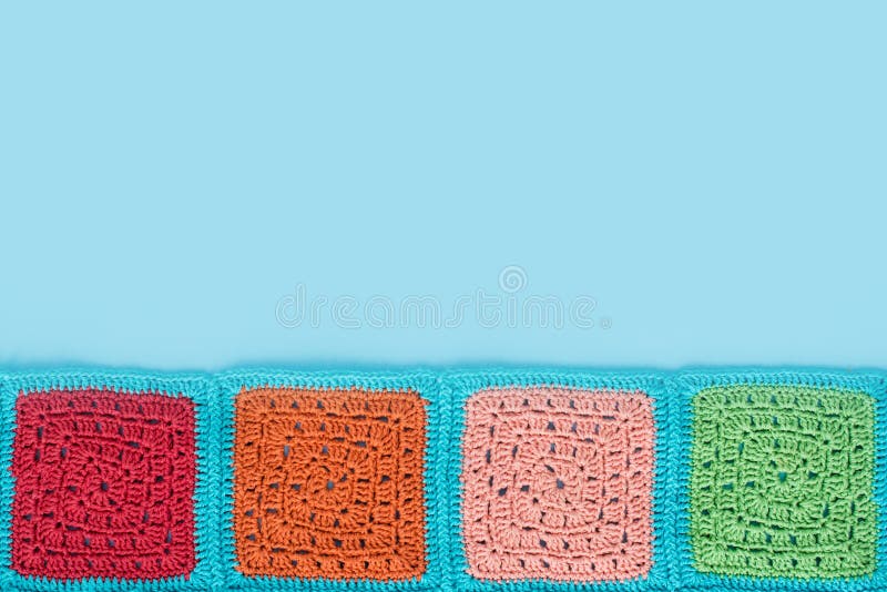 het gehaakte kanttafelkleed van multicolored vierkanten siert op een bluachtergrond, hoogste mening, plaats voor tekst, natuurlij stock foto het gehaakte kanttafelkleed van multicolored vierkanten siert op een bluachtergrond, hoogste mening, plaats voor tekst, natuurlij stock foto