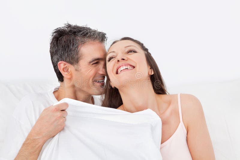 Het geknuffel van de man en van de vrouw in bed stock fotografie Het geknuffel van de man en van de vrouw in bed stock fotografie