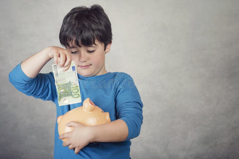 Het geld van de kindbesparing in een spaarvarken stock foto's Het geld van de kindbesparing in een spaarvarken stock foto's