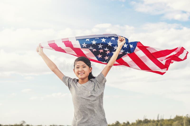 Het gelukkige Aziatische meisje met Amerikaanse vlag de V.S. viert 4 van Juli stock afbeelding Het gelukkige Aziatische meisje met Amerikaanse vlag de V.S. viert 4 van Juli stock afbeelding