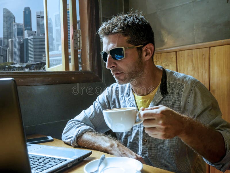 Het gelukkige en succesvolle jonge zakenman werken ontspande van Internet-koffiewinkel met laptop computer en mobiele telefoon do stock afbeelding Het gelukkige en succesvolle jonge zakenman werken ontspande van Internet-koffiewinkel met laptop computer en mobiele telefoon do stock afbeelding
