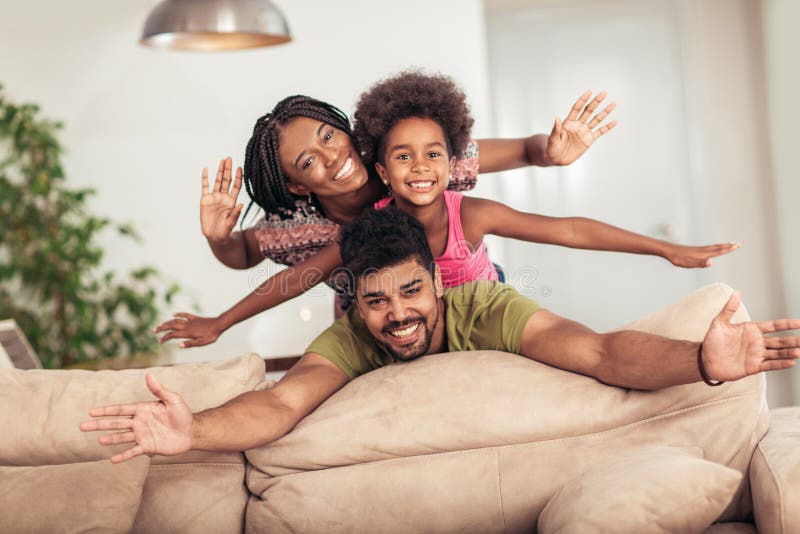 Het gelukkige familie stellen op de laag samen thuis stock foto Het gelukkige familie stellen op de laag samen thuis stock foto