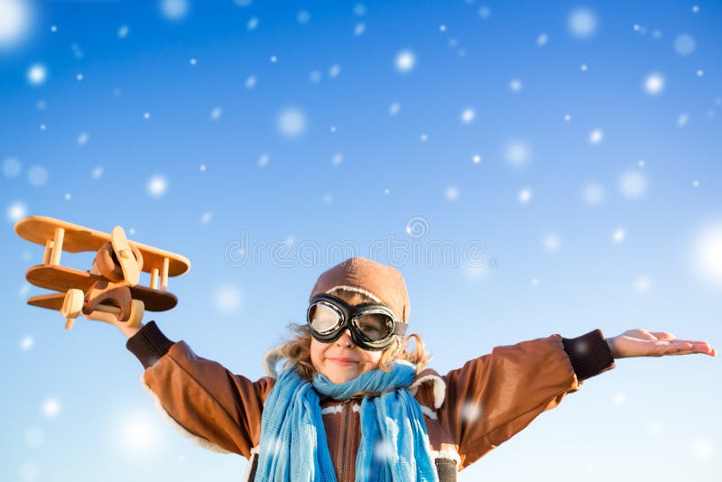 Het gelukkige jong geitje spelen met stuk speelgoed vliegtuig in de winter stock foto Het gelukkige jong geitje spelen met stuk speelgoed vliegtuig in de winter stock foto