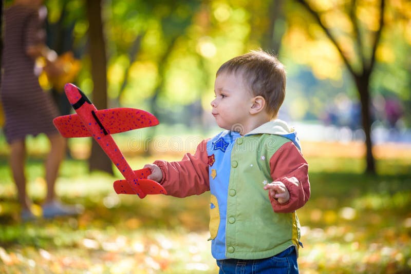 Het gelukkige jong geitje spelen met stuk speelgoed vliegtuig tegen de blauwe achtergrond van de de zomerhemel De jongen werpt sc royalty-vrije stock foto's Het gelukkige jong geitje spelen met stuk speelgoed vliegtuig tegen de blauwe achtergrond van de de zomerhemel De jongen werpt sc royalty-vrije stock foto's