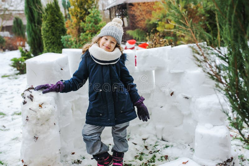 het gelukkige jong geitjemeisje kasteel van de de bouwsneeuw op de wintervakantie stock afbeeldingen het gelukkige jong geitjemeisje kasteel van de de bouwsneeuw op de wintervakantie stock afbeeldingen