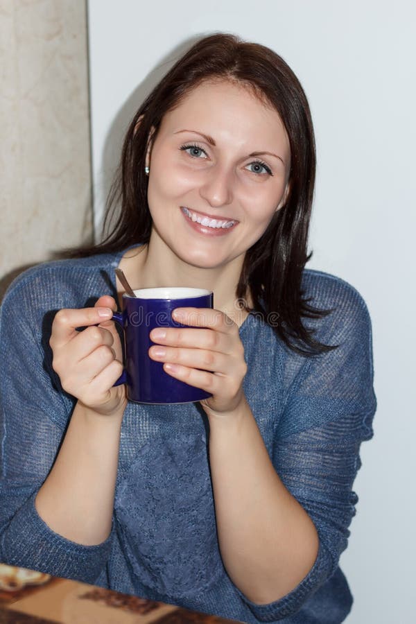 Het gelukkige meisje zit bij een lijst en heeft aftreksel stock fotografie Het gelukkige meisje zit bij een lijst en heeft aftreksel stock fotografie