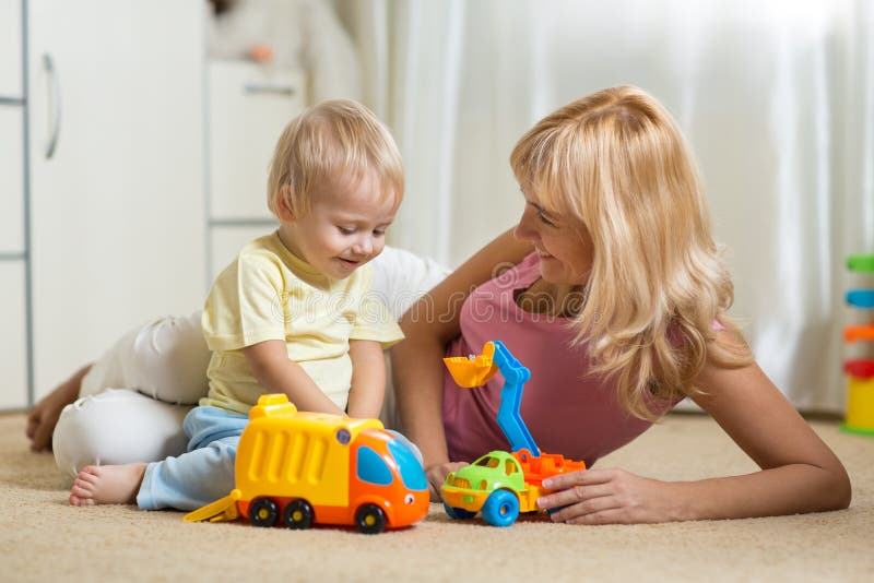 Het gelukkige moeder spelen met babyjongen thuis stock fotografie Het gelukkige moeder spelen met babyjongen thuis stock fotografie