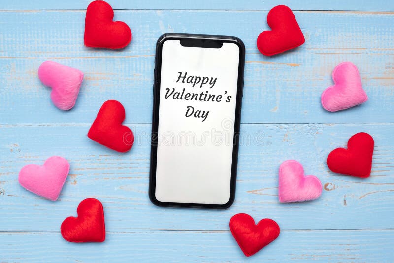 Het gelukkige Valentine’s-Dagwoord op witte touchscreen vertoning van zwarte smartphone met rode en roze harten vormt decoratie stock afbeeldingen Het gelukkige Valentine’s-Dagwoord op witte touchscreen vertoning van zwarte smartphone met rode en roze harten vormt decoratie stock afbeeldingen