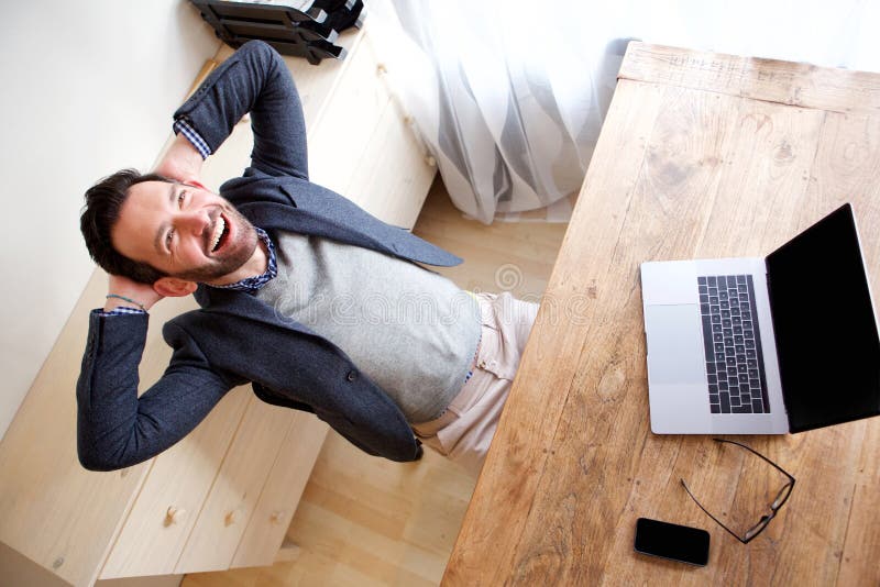 Het gelukkige zakenman ontspannen in bureau met laptop stock foto Het gelukkige zakenman ontspannen in bureau met laptop stock foto