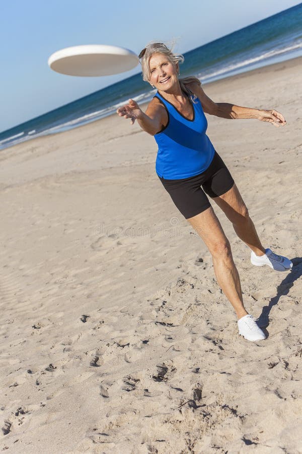 Gezonde Hogere Vrouw die Frisbee spelen bij Strand royalty-vrije stock afbeeldingen Gezonde Hogere Vrouw die Frisbee spelen bij Strand royalty-vrije stock afbeeldingen