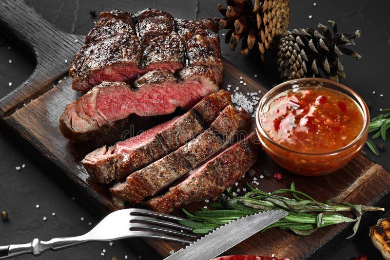 Het gesneden geroosterde middelgrote zeldzame rundvleeslapje vlees diende op houten raadsbarbecue, bbq het haasbiefstuk van het v royalty-vrije stock afbeeldingen Het gesneden geroosterde middelgrote zeldzame rundvleeslapje vlees diende op houten raadsbarbecue, bbq het haasbiefstuk van het v royalty-vrije stock afbeeldingen