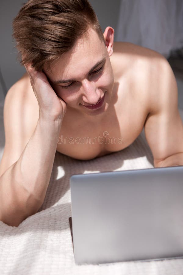 Het gespierde mens online babbelen met meisje op bed stock foto's Het gespierde mens online babbelen met meisje op bed stock foto's