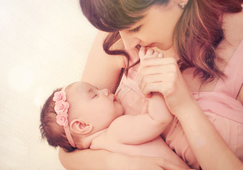 Het geven moeder het kussen vingers van haar leuk meisje van de slaapbaby