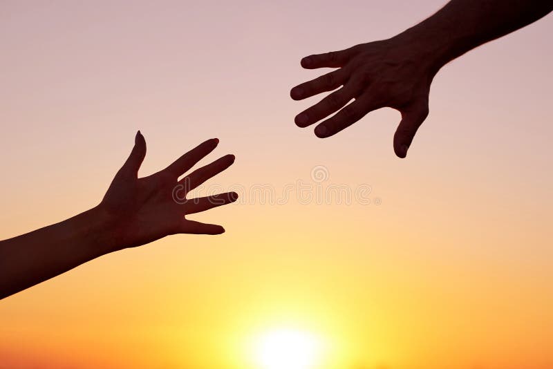 Het geven van een helpende hand Silhouet Twee handen, man en vrouw, die naar elkaar bij hemelzonsondergang bereiken