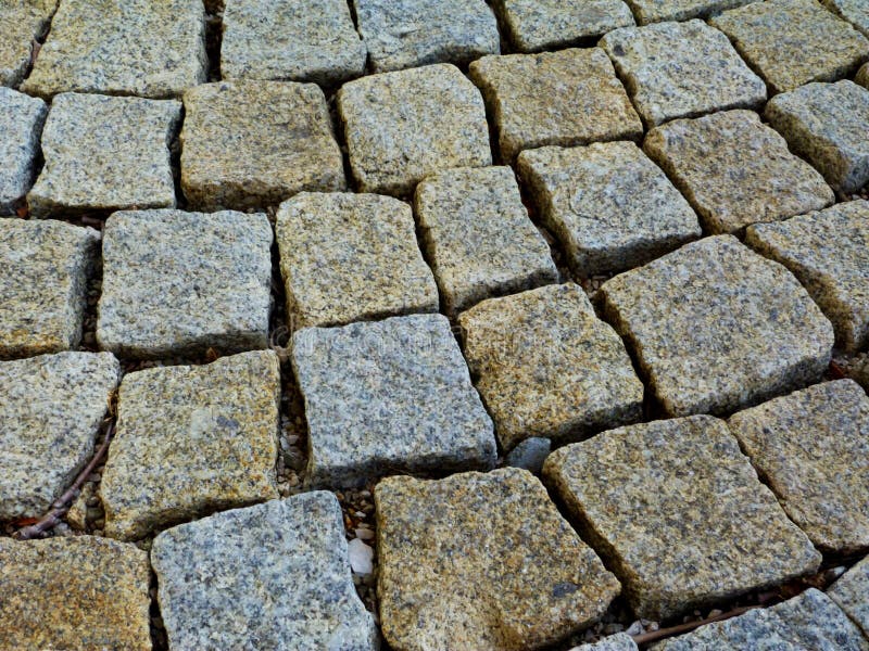 Het geweven en rustieke detail van de de steenbestrating van het kubuskwarts van vierkante vormen plaatste los stock afbeelding Het geweven en rustieke detail van de de steenbestrating van het kubuskwarts van vierkante vormen plaatste los stock afbeelding