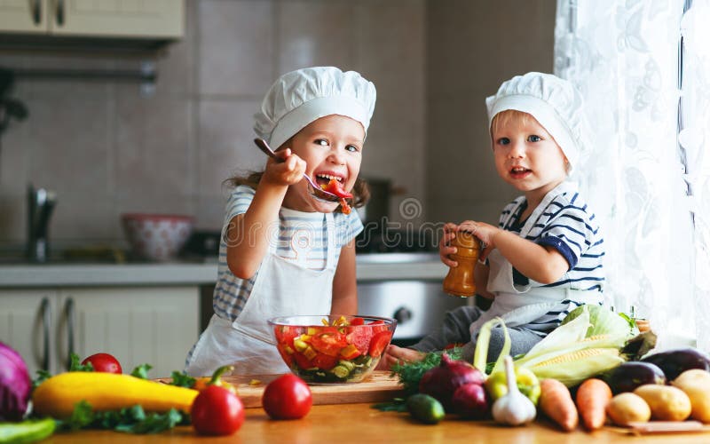 Het gezonde Eten De gelukkige kinderen bereidt plantaardige salade in kitc voor royalty-vrije stock afbeeldingen Het gezonde Eten De gelukkige kinderen bereidt plantaardige salade in kitc voor royalty-vrije stock afbeeldingen
